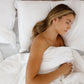 Woman sleeping in a bed with white vegan ethical silk bedding