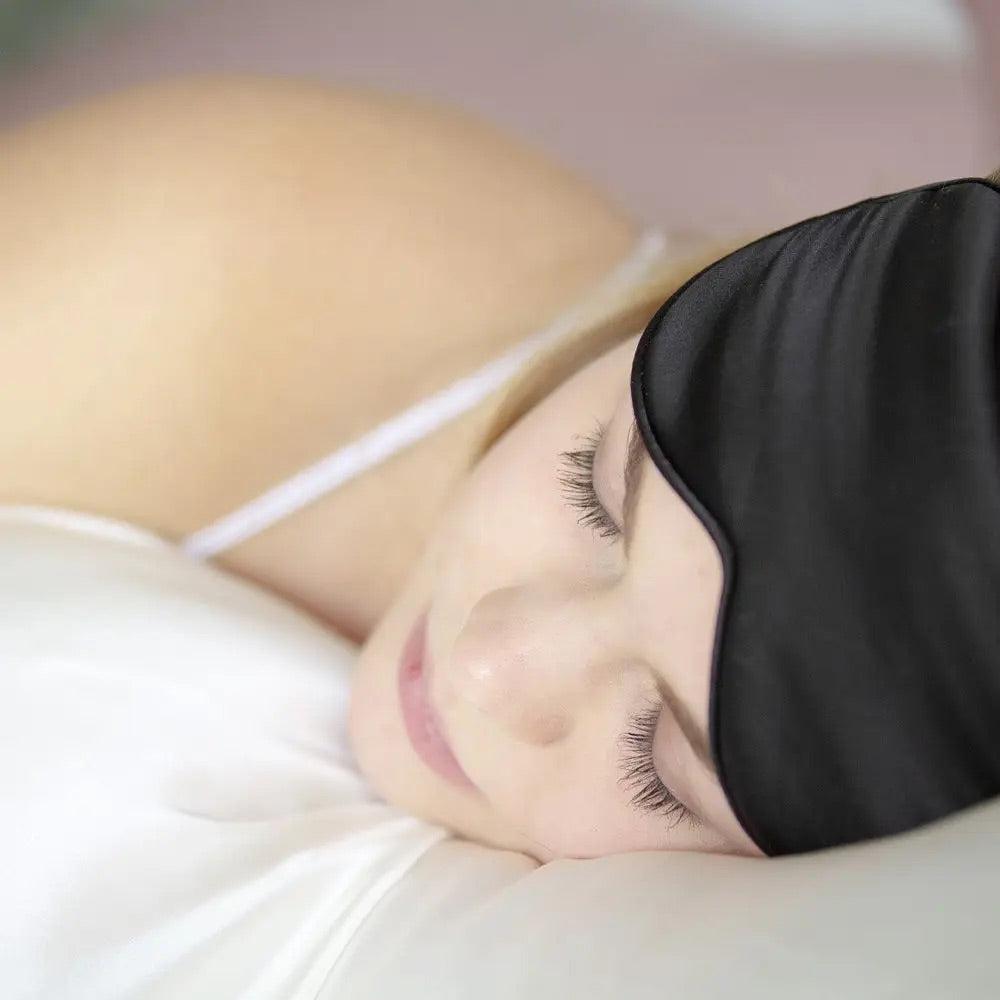 Woman sleeping with a black silk sleep eye mask