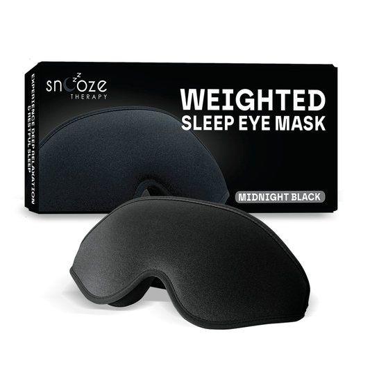 Black weighted sleep eye mask with Snooze Therapy packaging on a white background