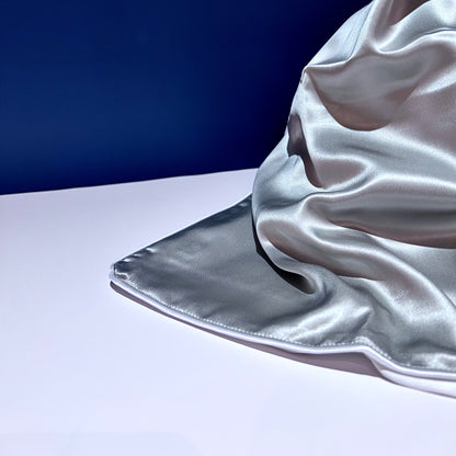 Silk pillowcase draped on blue and white background