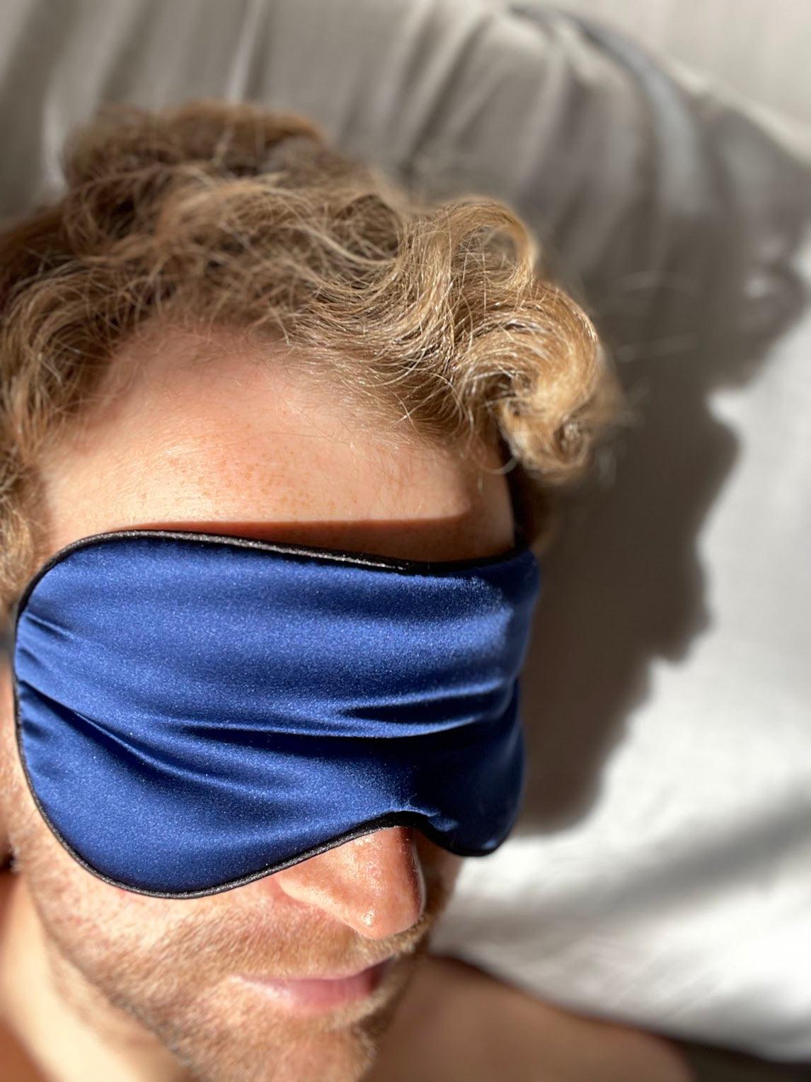 Man with blonde hair and a beard wearing a blue silk sleep eye mask