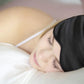 Woman sleeping with a black silk sleep eye mask