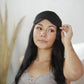 Woman with black hair wearing a black silk eye mask