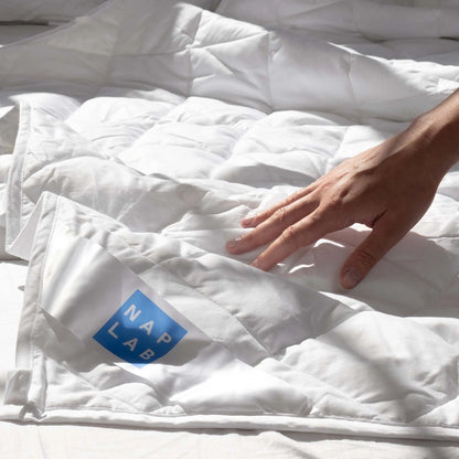 A hand touching a weighted blanket